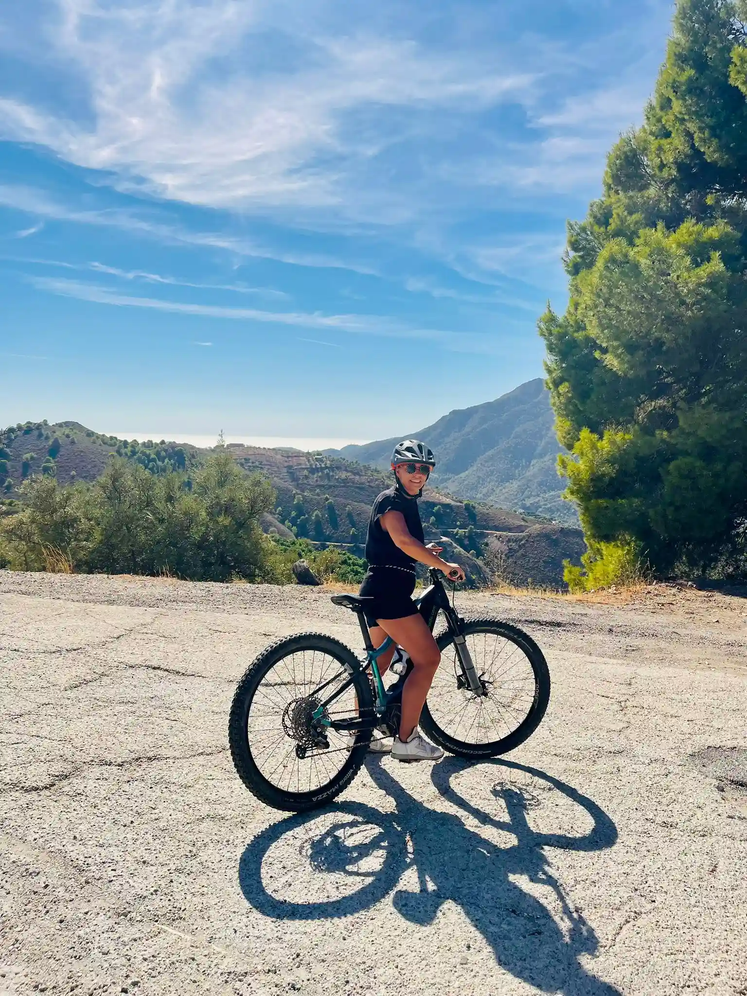 ciclista mirando la sierra con cicicleta a su lado