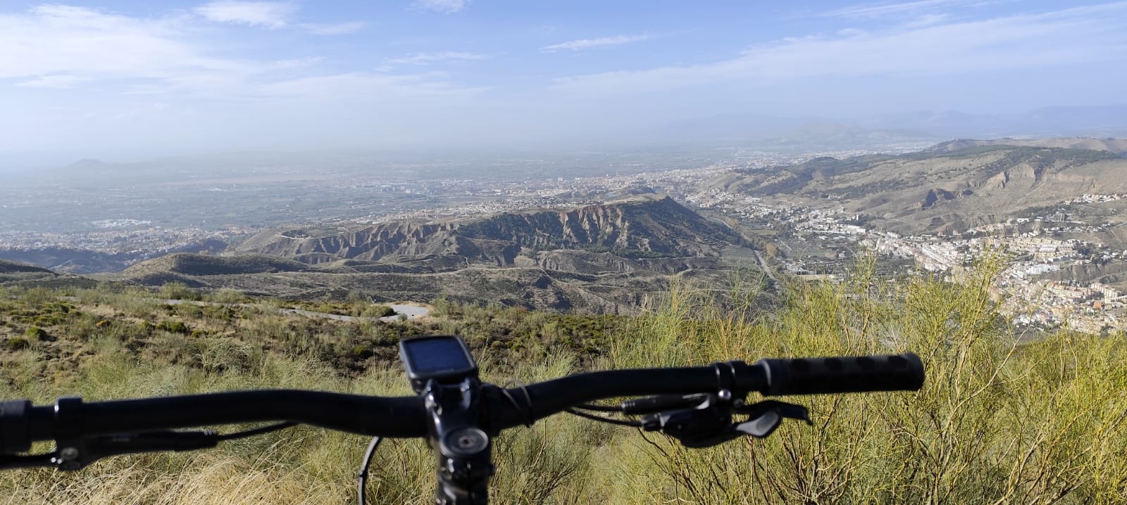 ciclista mirando la sierra con cicicleta a su lado