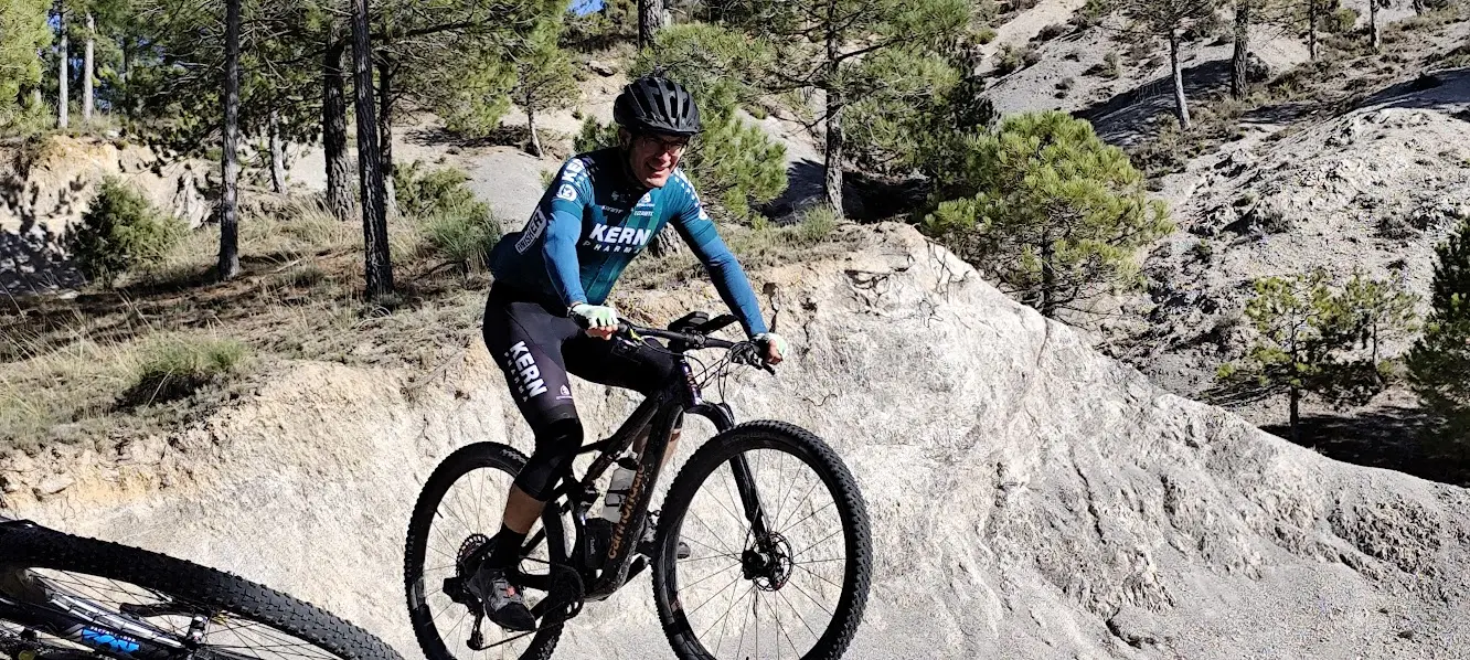 ciclista mirando la sierra con cicicleta a su lado