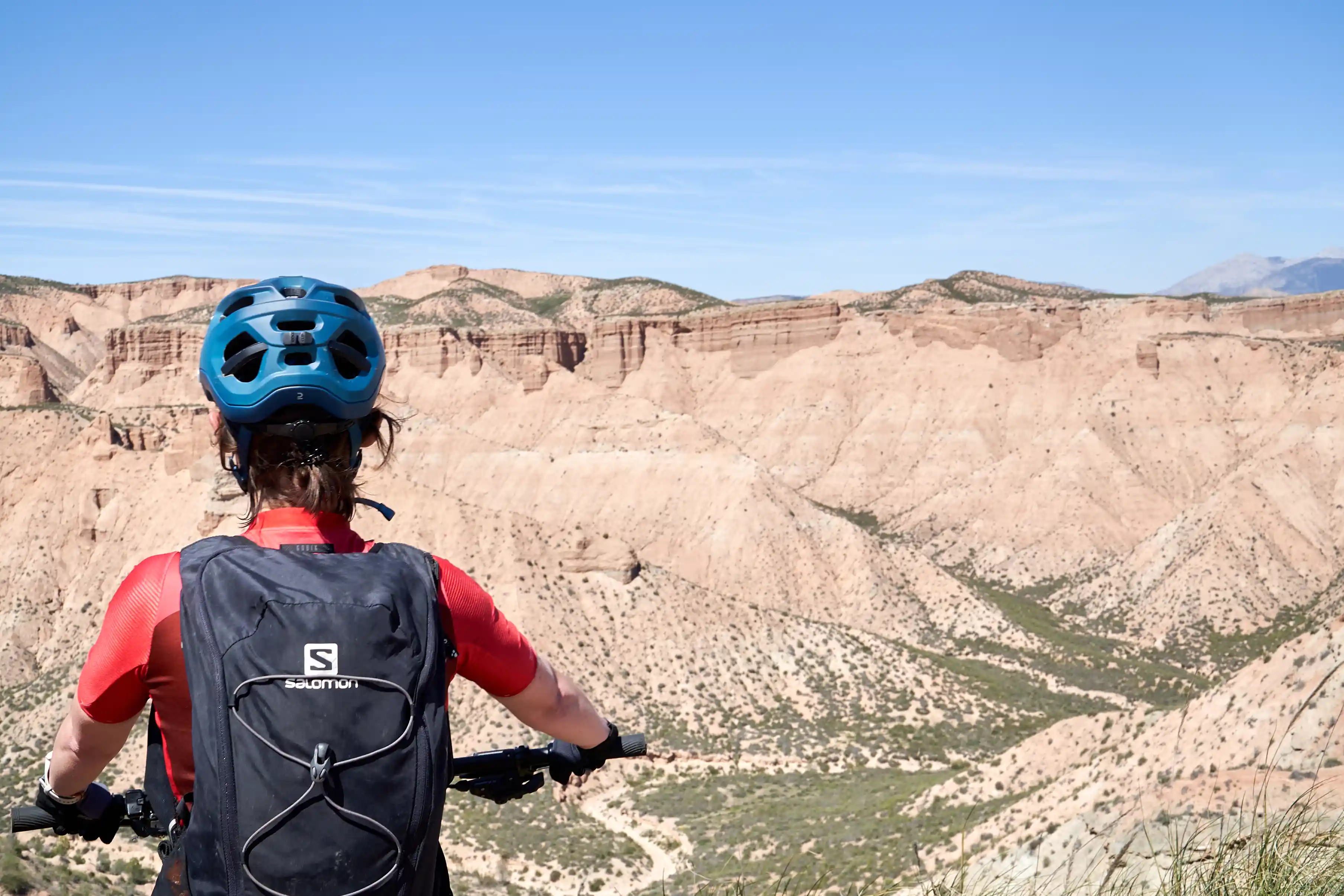 ciclista mirando la sierra con cicicleta a su lado